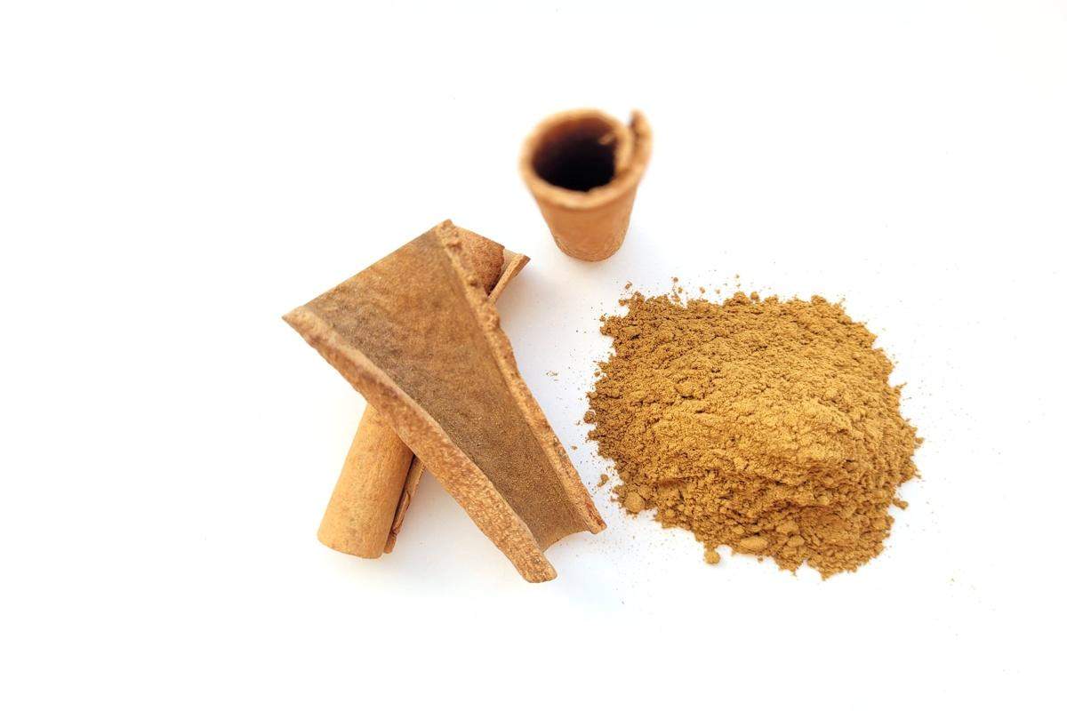 Aromatyczny cynamon w formie lasek i mielonego proszku, ułożony na drewnianym tle — symbol naturalnych przypraw wspierających smak i zdrowie