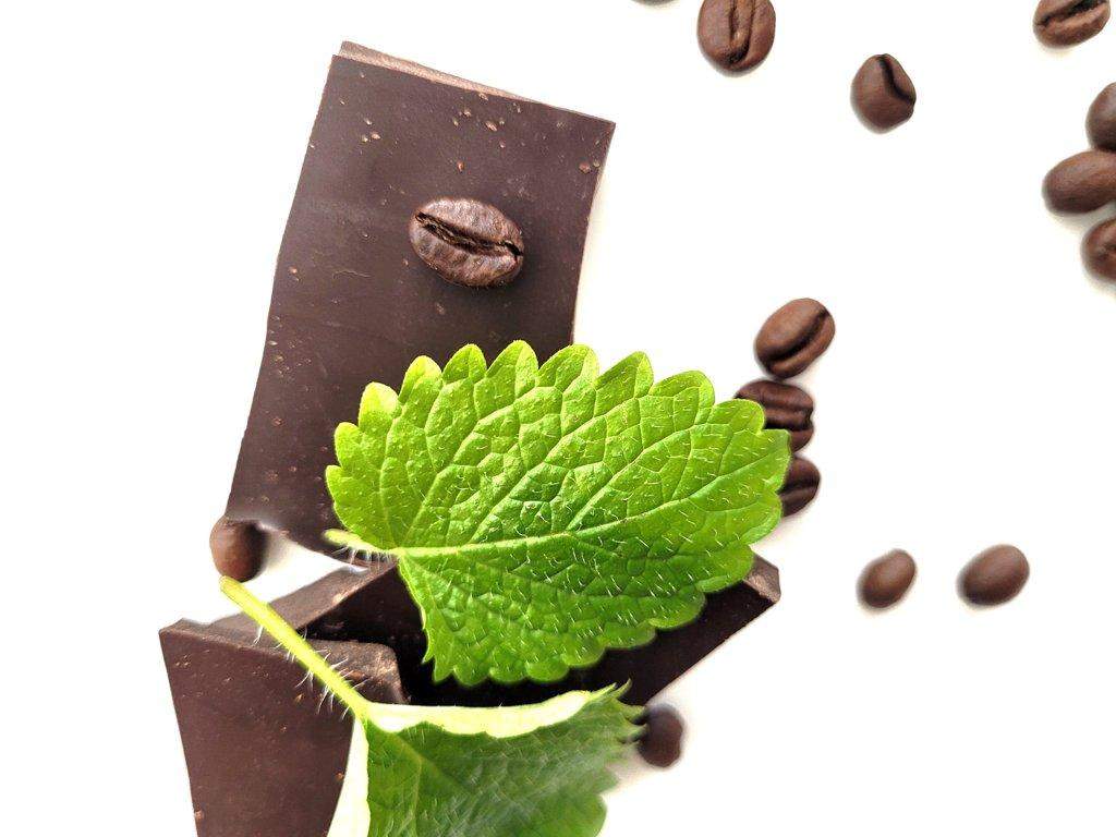Zdjęcie czekolady i dekoracji w postaci ziaren kawy i listka mięty